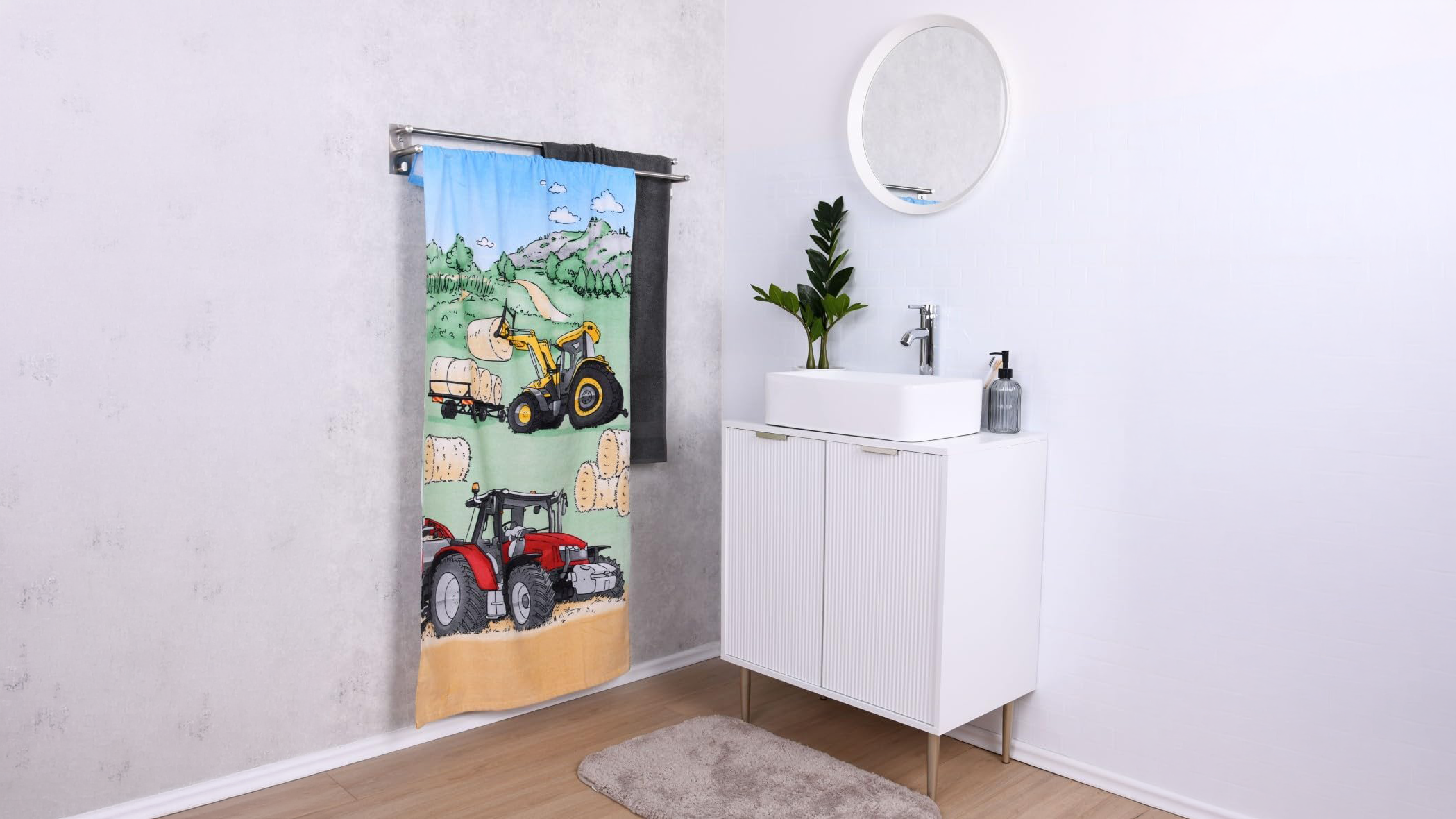 Kinder-Badetuch mit Traktor- und Bagger-Motiv auf Handtuchhalter im modernen Badezimmer – Badtextilien für Kinder