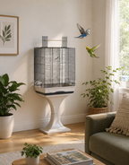 Das Vogelkäfig-Modell "Ambra mit Ständer" mit schwarzem Gitter und weißer Bodenschale, elegant auf einem passenden Ständer in einem hellen, pflanzenreichen Wohnzimmer platziert, während zwei Wellensittiche umherfliegen.