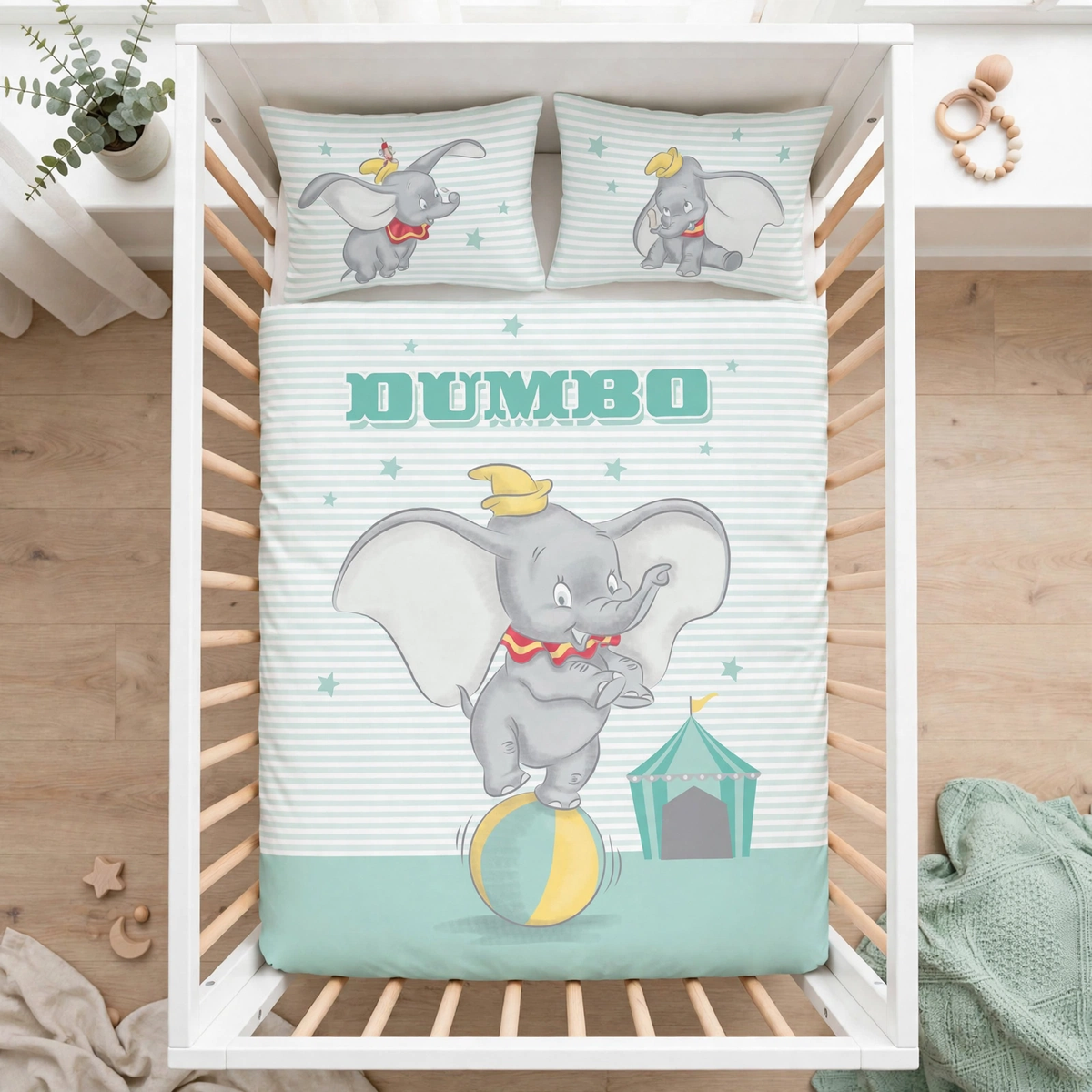 Herding Baby Bettwäsche Disney Dumbo 100 x 135 cm 100% Baumwolle in einem Babybett dargestellt. Ansicht aus der Vogelperspektive.