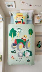 Draufsicht aus der Vogelperspektive auf das ordentlich gemachte Kinderbett mit der komplett gemusterten Bauernhof-Bettwäsche im hellen Zimmer.