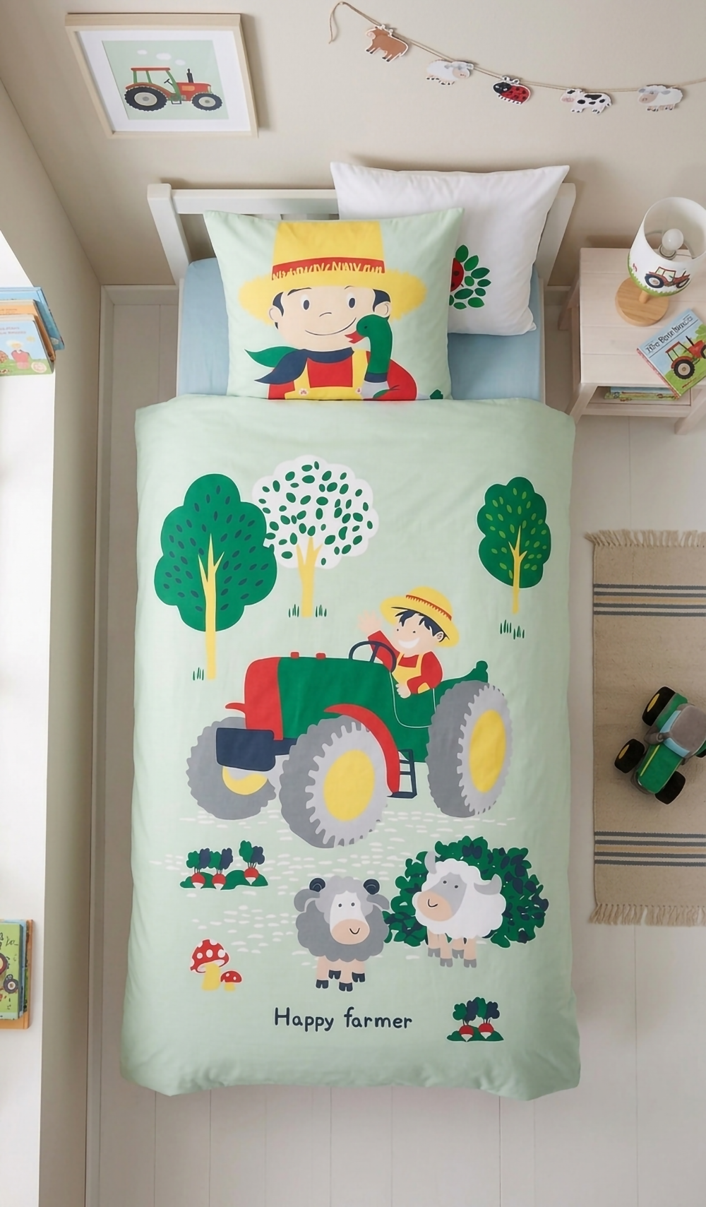 Draufsicht aus der Vogelperspektive auf das ordentlich gemachte Kinderbett mit der komplett gemusterten Bauernhof-Bettwäsche im hellen Zimmer.