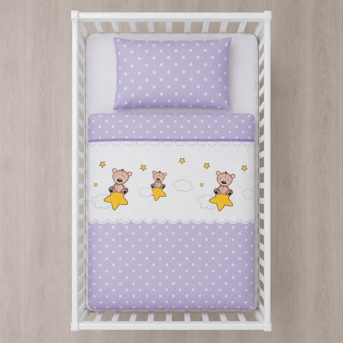 Babybettwäsche Bär und Sterne Lila 100x135 cm 100% Baumwolle in einem Babybett aus der Vogelperspektive dargestellt