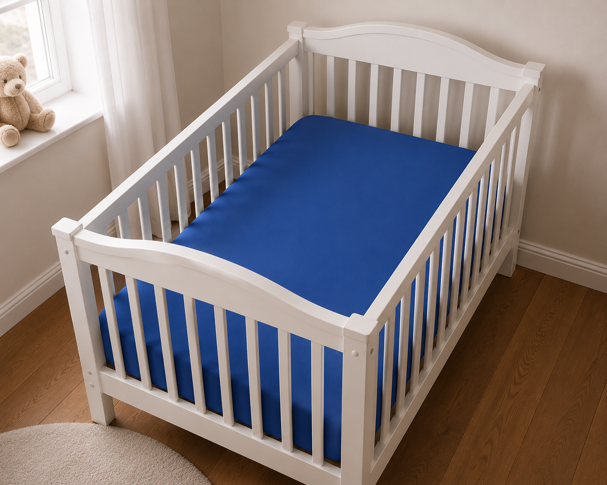 2er Set Baby Jersey Spannbetttuch 60x120 cm - 70x140 cm Blau Baumwolle aus einer schrägen Perspektive in einem Babybett dargestellt