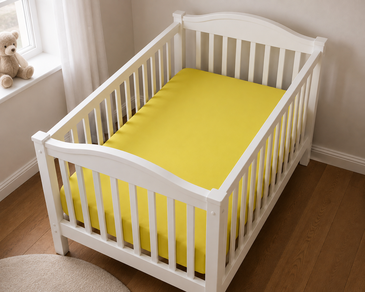 2er Set Baby Jersey Spannbetttuch 60x120 cm - 70x140 cm Gelb Baumwolle  aus einer schrägen Perspektive in einem Babybett dargestellt