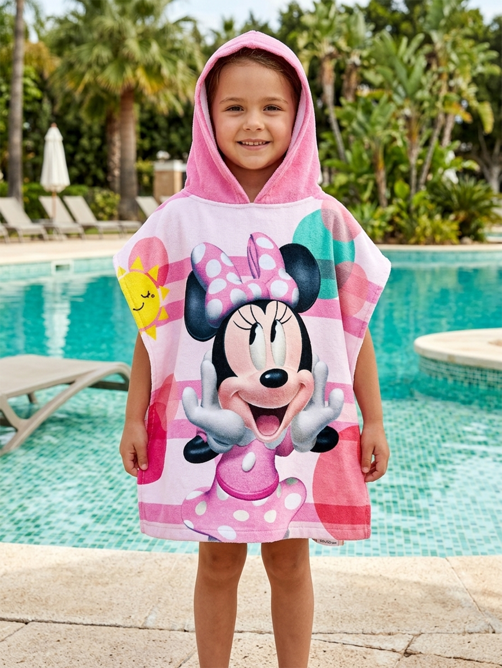 Mädchen trägt einen Minnie Mouse Badeponcho Kinder Poncho mit Kapuze 50x100cm Baumwolle. Im Hintergrund ist ein Pool.