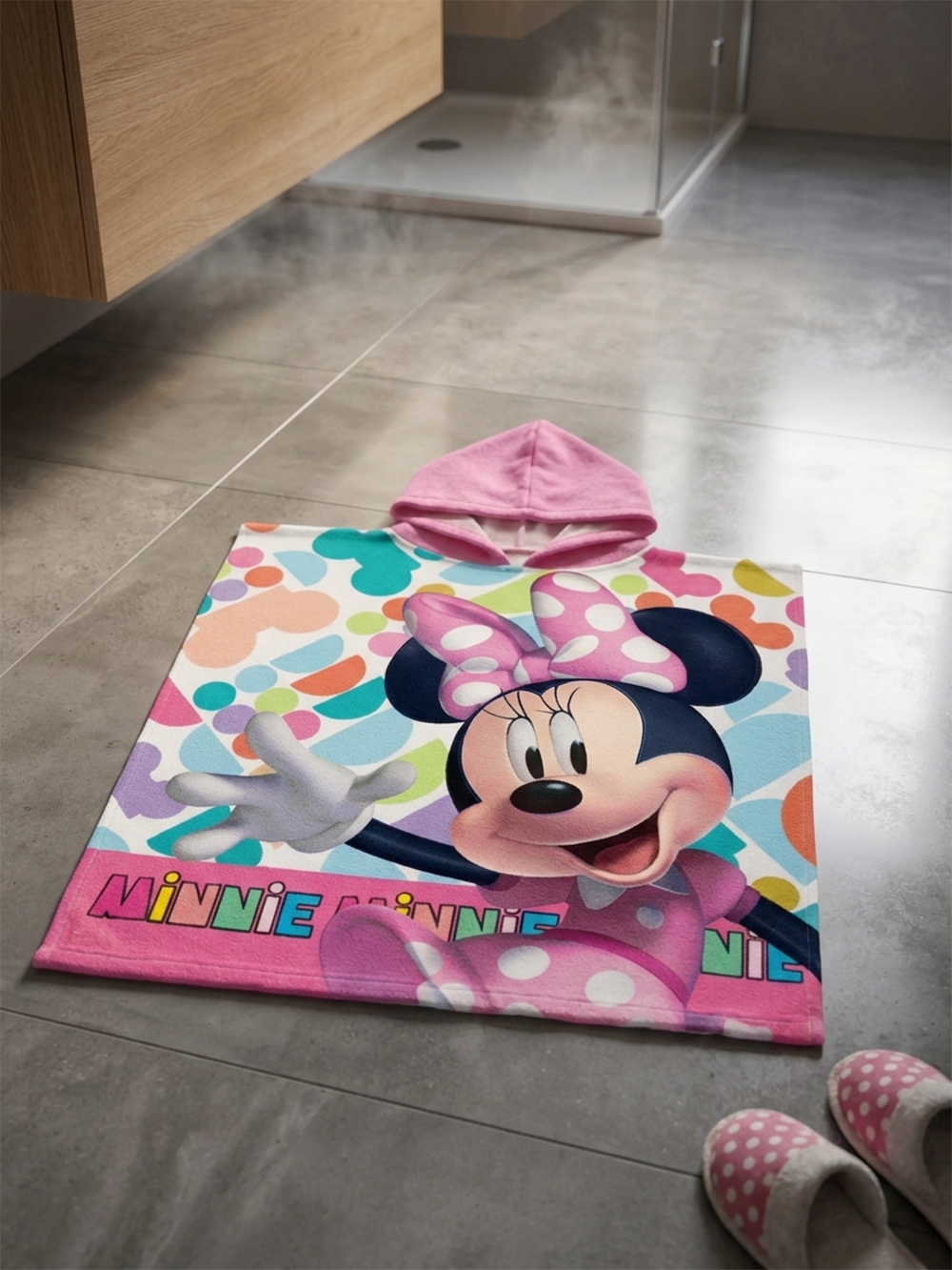 Minnie Mouse Badeponcho Kinder Poncho mit Kapuze 50x100cm Baumwolle liegend auf einem Badezimmerboden.