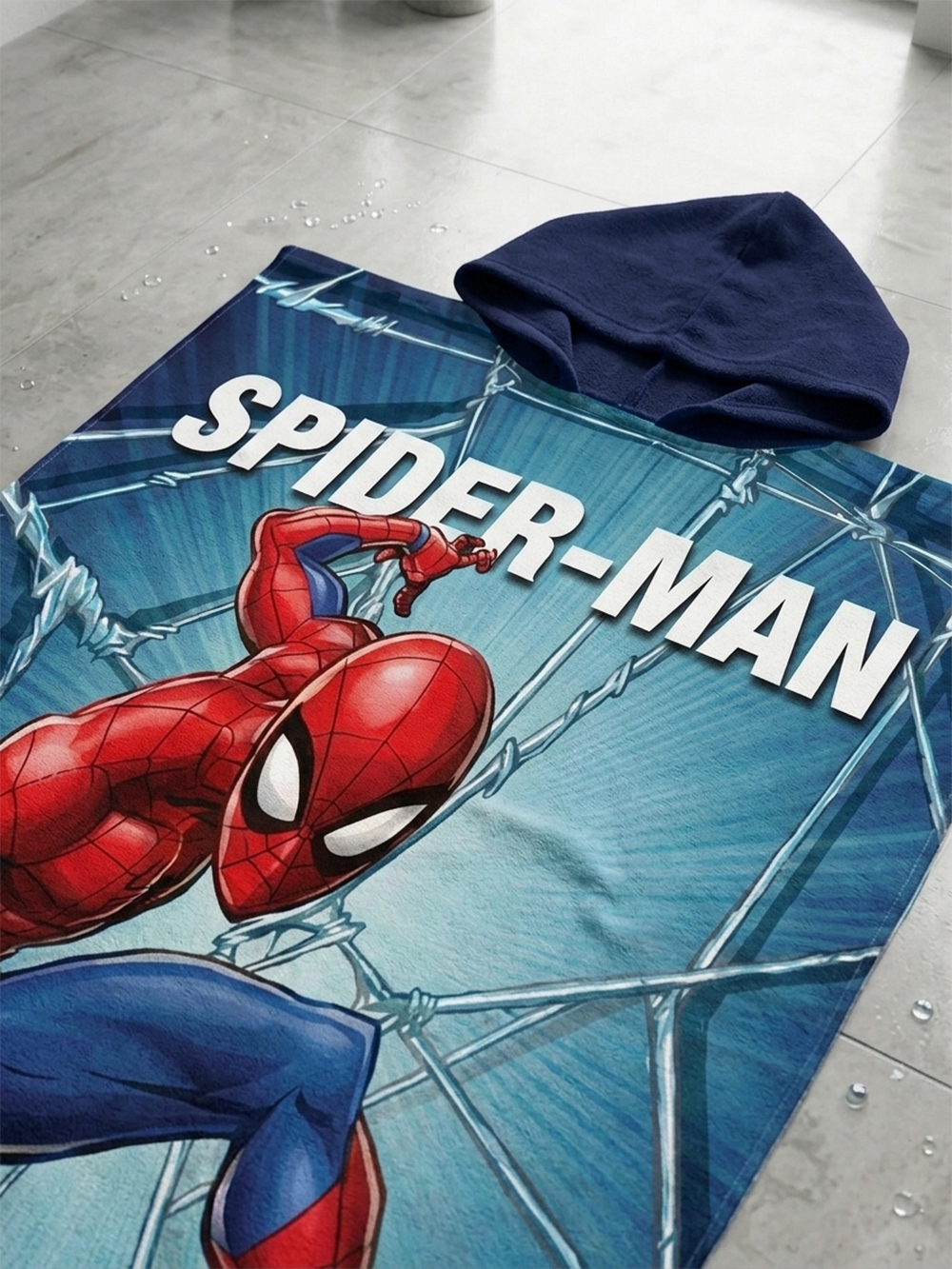 Nahaufnahme vom Spiderman Badeponcho Kinder Poncho mit Kapuze 50x100cm, 100% Baumwolle auf einem Badezimmerboden.