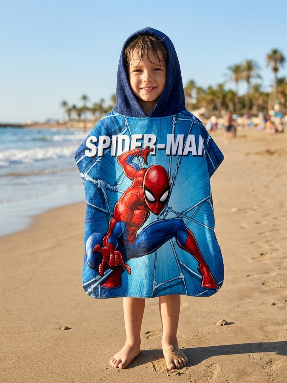 Junge steht am Strand und trägt einen Spiderman Badeponcho Kinder Poncho mit Kapuze 50x100cm, 100% Baumwolle