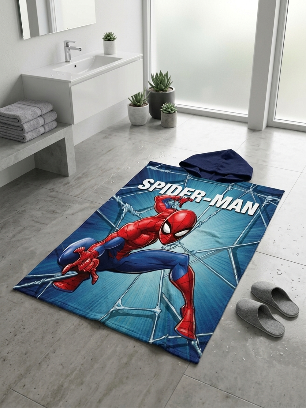 Spiderman Badeponcho Kinder Poncho mit Kapuze 50x100cm, 100% Baumwolle liegt auf einem Badezimmerboden.