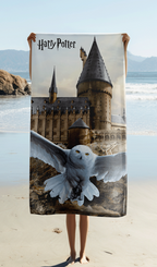 Person hält das Harry Potter Hedwig Hogwarts Duschtuch Badetuch 70 x 140 cm Baumwolle in der Hand