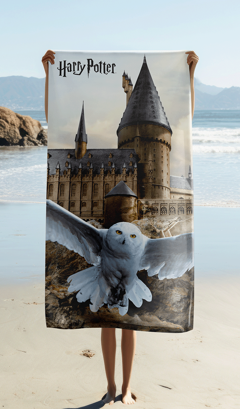 Person hält das Harry Potter Hedwig Hogwarts Duschtuch Badetuch 70 x 140 cm Baumwolle in der Hand