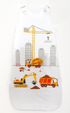 Herding babybest® Baustelle Ganzjahres-Schlafsack für Babys Baumwolle. Motiv mit Kran, Bagger und Betonmischer. Im Hintergrund befinden sich Hochhäuser. Liegend auf einer Oberfläche.