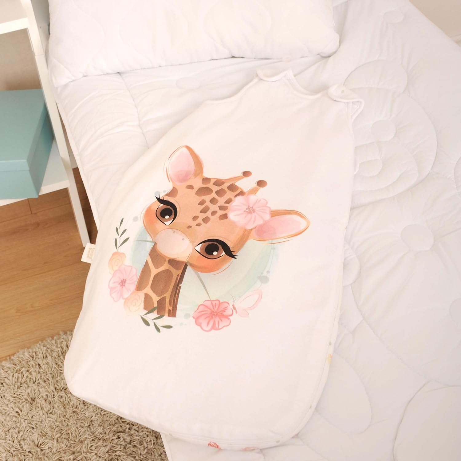 Herding babybest® Giraffe Ganzjahres-Schlafsack für Babys Baumwolle. Liegend auf einem Bett präsentiert.