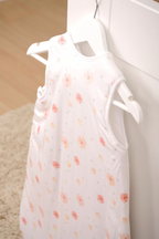 Herding babybest® Giraffe Ganzjahres-Schlafsack für Babys Baumwolle mit Allover-Blumenmuster auf der Rückseite. Aufgehangen an einem Haken.