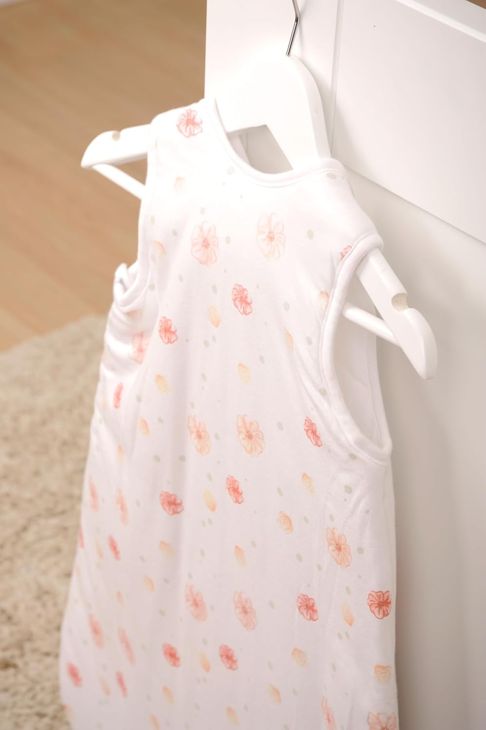 Herding babybest® Giraffe Ganzjahres-Schlafsack für Babys Baumwolle mit Allover-Blumenmuster auf der Rückseite. Aufgehangen an einem Haken.