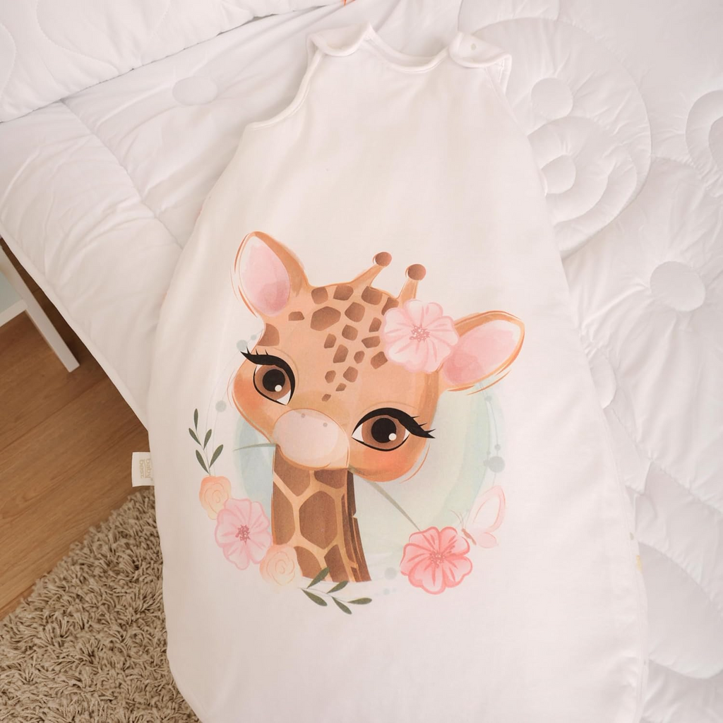 Herding babybest® Giraffe Ganzjahres-Schlafsack für Babys Baumwolle. Liegend auf einem Bett präsentiert.