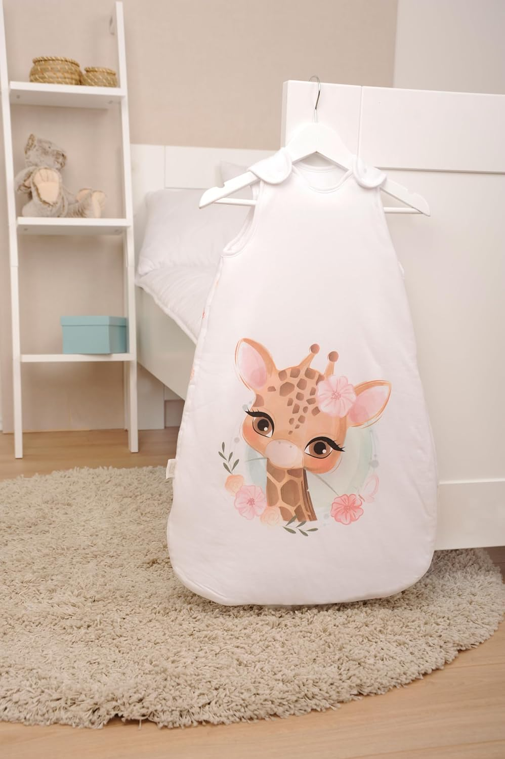 Herding babybest® Giraffe Ganzjahres-Schlafsack für Babys Baumwolle Vorderseite und Rückseite. Giraffe mit Blumen auf der Vorderseite. Aufgehangen an einem Haken.