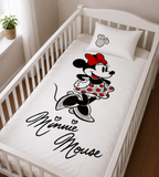 Disney Minnie Mouse Baby Bettwäsche 100 x 135 cm 100% Baumwolle in einem Babybett dargestellt. Schräge Ansicht auf die Bettwäsche im Babybett.