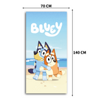 Bluey Kinder-Badetuch mit Maßangaben (70 cm Breite, 140 cm Länge). Das Motiv zeigt Bluey und Bingo, die sich am Sandstrand umarmen, unter dem weißen Serienschriftzug.