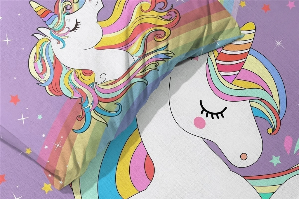 Nahaufnahme lila Unicorn‑Bettwäsche mit weißem Einhorn, Regenbogenmähne und Sternen. Kissen und Decke im gleichen Motiv.