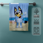 Frontansicht eines Bluey‑Handtuchs am Stab, Bluey am Strand, daneben Icons zu Baumwolle, Saugfähigkeit und Pflegeleichtigkeit.