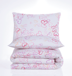 Gefaltetes Bettwäsche‑Set mit weißem Stoff und bunten Herzumrissen in Pink, Lila, Orange und Rot. Kissen und Decke im gleichen Muster.
