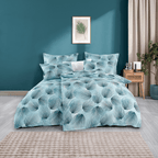 Bett mit hellblauer Bettwäsche mit dunkelblauem Fächermuster. Modernes Zimmer mit Holz‑Nachttisch, Pflanze, Wandbild und beige Vorhängen.