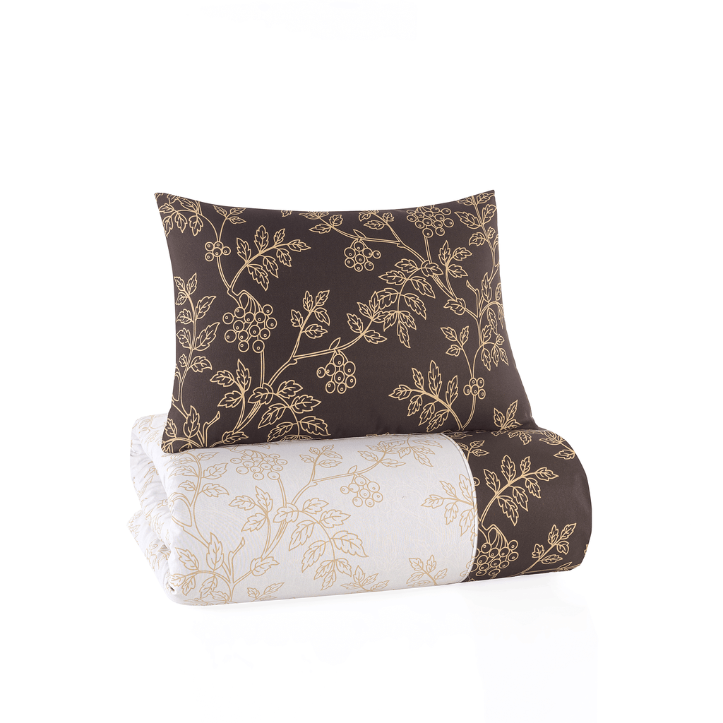 Gefaltetes Bettwäsche‑Set mit dunkelbraunem Kissen mit goldenen Blättern und heller Decke mit goldfarbenem botanischem Muster.