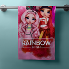 Hängendes Handtuch mit zwei Rainbow‑High‑Figuren in Pink und Rot. Unten „RAINBOW HIGH“ Logo.