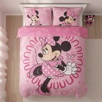 Pinkfarbene Minnie Mouse Kinderbettwäsche in der Draufsicht auf einem Bett; das Design zeigt die Disney-Figur in einem gemusterten Kreis auf der Decke sowie zwei passende Kissenbezüge.