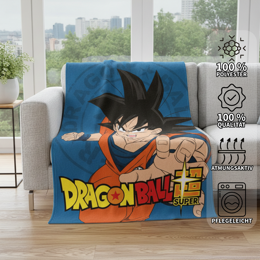 Blaue Dragon Ball Super Decke ausgebreitet auf einer grauen Couch im Wohnzimmer; am rechten Bildrand sind vier Eigenschafts-Icons mit den Texten „100% Polyester“, „100% Qualität“, „Atmungsaktiv“ und „Pflegeleicht“ zu sehen.