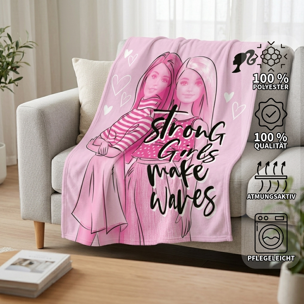 Ambiente-Aufnahme der rosa Barbie-Fleecedecke auf einer grauen Couch; auf der rechten Seite zeigen vier Icons die Eigenschaften: 100% Polyester, 100% Qualität, atmungsaktiv und pflegeleicht.