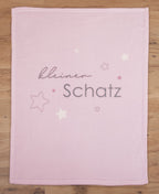 Glatt und gerade ausgebreitete rosa Babydecke in der direkten Draufsicht auf Holzboden.