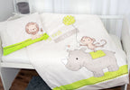Ambiente-Aufnahme der Babybettwäsche in einem weißen Gitterbett; die Decke zeigt das Nashorn- und Affenmotiv, während auf dem passenden Kopfkissen ein kleiner Löwe abgebildet ist.