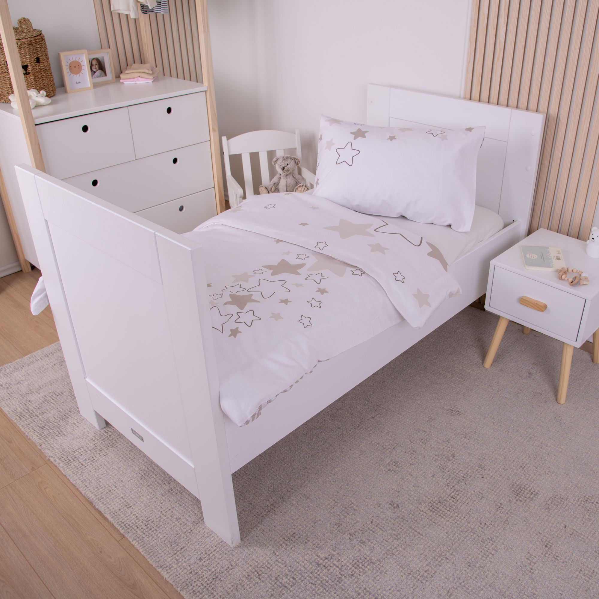 Weitere Schlafzimmer-Ansicht des Gitterbettes; hier ist die Decke tiefer zurückgeschlagen, wodurch auch die Sternen-Musterung auf dem Kissen gut zur Geltung kommt.
