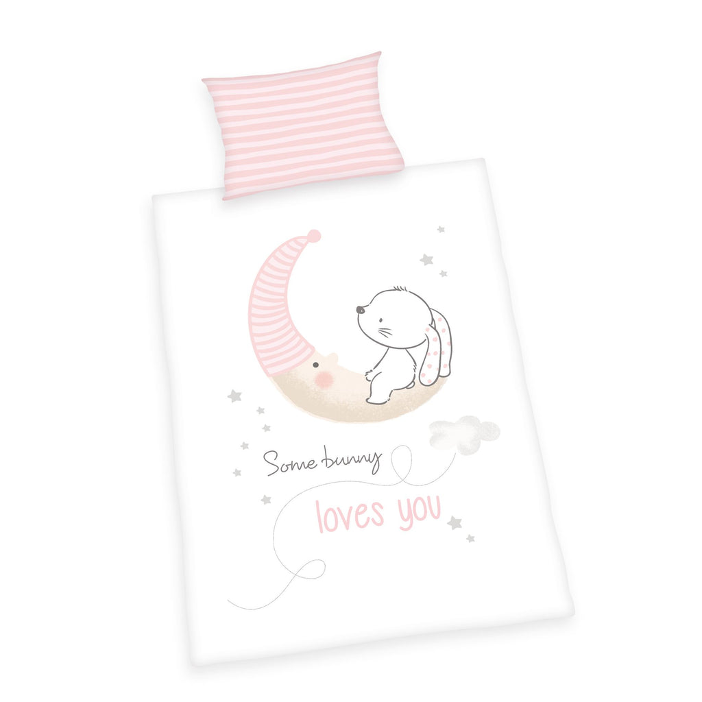 Produktansicht der Babybettwäsche freigestellt auf weißem Hintergrund; zeigt das komplette Set bestehend aus dem rosa-weiß gestreiften Kissen und dem Deckenbezug mit dem zentralen Hasen-Motiv in der direkten Draufsicht.