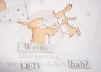 Nahaufnahme der weißen Kinderbettwäsche „Weißt du eigentlich, wie lieb ich dich hab?“; zeigt den großen und den kleinen Hasen beim gemeinsamen Spielen sowie den bekannten Buchtitel als gestalteten Schriftzug.