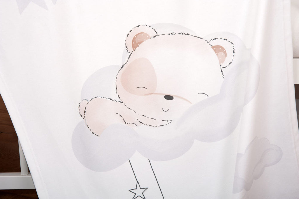 Nahaufnahme der Babydecke; fokussiert auf das detailreich gestaltete, schlafende Bären-Baby mit geschlossenen Augen, das gemütlich auf einer großen Wolke liegt.