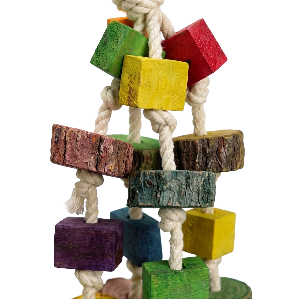 Detailreiche Nahaufnahme freigestellt auf schwarzem Hintergrund; zeigt die Textur der bunten Holzklötze, Rindenstücke und der robusten, geknoteten Baumwollseile im oberen Bereich.