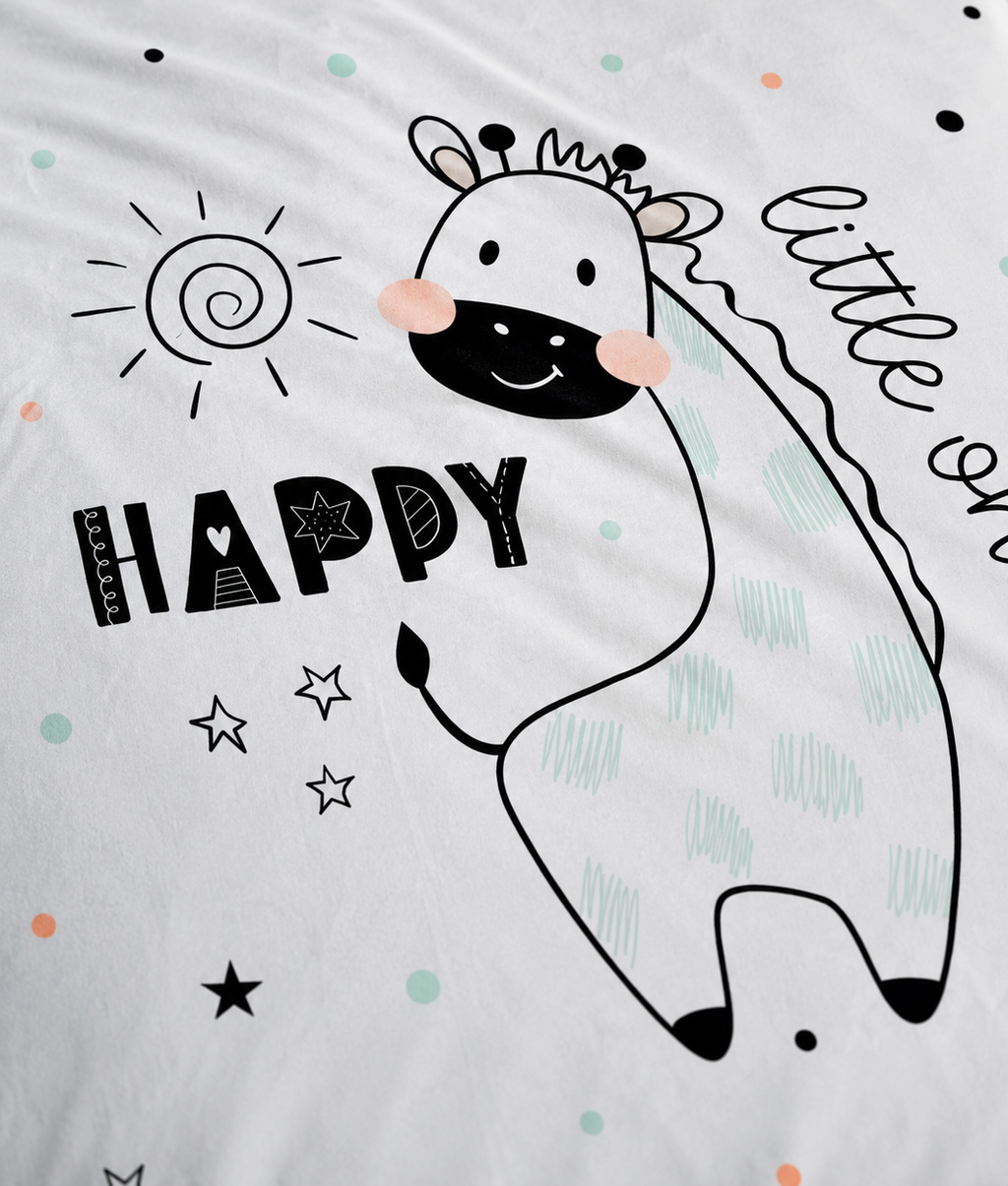 Detailaufnahme der Kinderbettwäsche aus Baumwolle mit gezeichneter Giraffe, Sonne, Sternen und dem Schriftzug „HAPPY little one“.