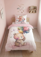 Leicht schräge Perspektive auf das bezogene Kinderbett in einem rosa Kinderzimmer mit Bären-Bettwäsche und fliegendem Bären auf dem Kissen.