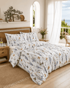 Aufgezogene Seersucker-Bettwäsche mit Blumen- und Schmetterlingsmuster auf einem Bett in einem mediterran eingerichteten Schlafzimmer.
