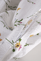 Detailaufnahme des verdeckt eingenähten Reißverschlusses an der weiß-beigen Seersucker-Bettwäsche mit Blumenprint.