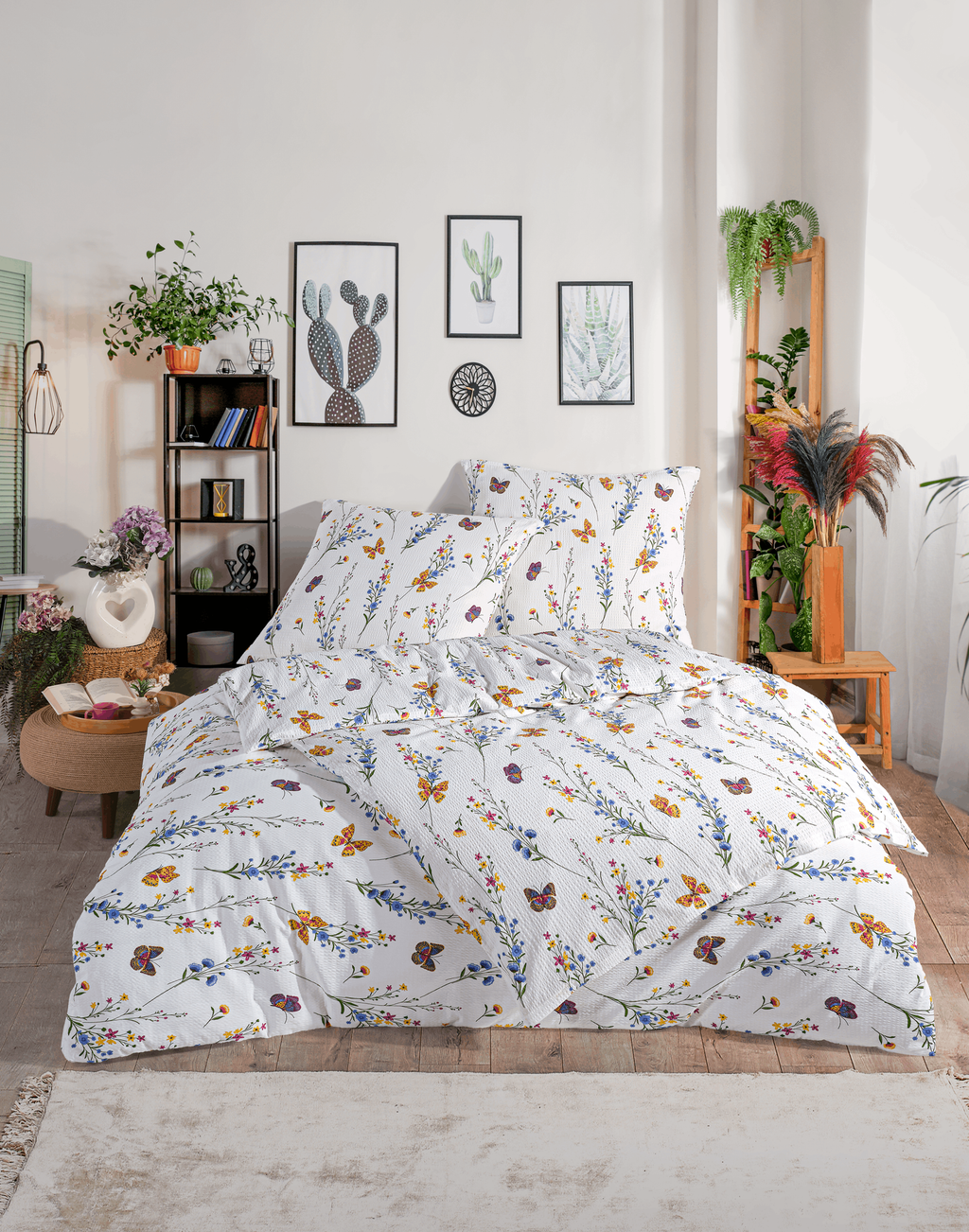 Bettwäsche-Set mit Blumen- und Schmetterlingsmotiv auf einem Doppelbett in moderner Raumkulisse mit Zimmerpflanzen.