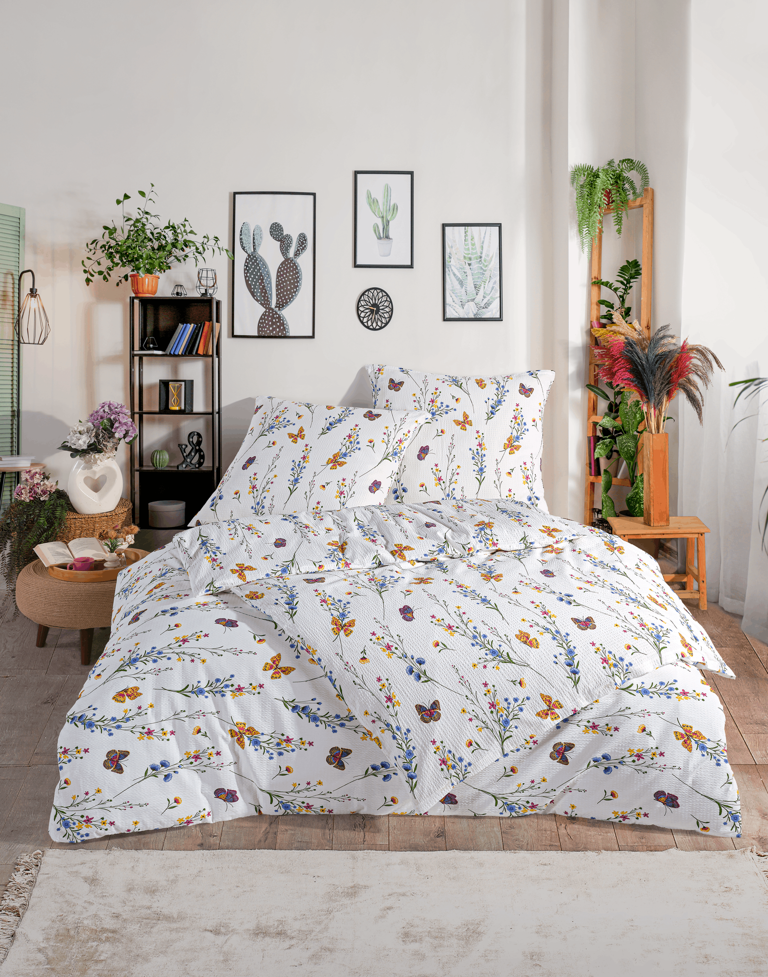 Bettwäsche-Set mit Blumen- und Schmetterlingsmotiv auf einem Doppelbett in moderner Raumkulisse mit Zimmerpflanzen.
