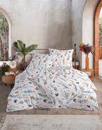 Reingeshoppte Ansicht des Doppelbetts mit Wiesenblumen-Seersucker-Bettwäsche vor einer mediterranen Steinwand-Kulisse.