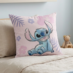 Nahaufnahme der Vorder- und Rückseite des blauen Stitch-Wendekissens mit Hawaii-Blumen-Print auf einem Bett.
