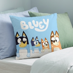 Nahaufnahme der blauen Vorderseite des Bluey-Kissens mit der ganzen Familie Heeler auf einem Bett.