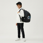 Junge mit weißem Hoodie und Cap trägt den schwarzen Fußball-Schulrucksack seitlich auf der Schulter. Schulrucksack Rucksack Studio V Top Scorers Fußball Goal Schwarz 44 cm