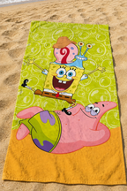 Ambiente Aufnahme vom SpongeBob Duschtuch Badetuch Strandtuch 70 x 140 cm 100% Baumwolle an einem Strand.